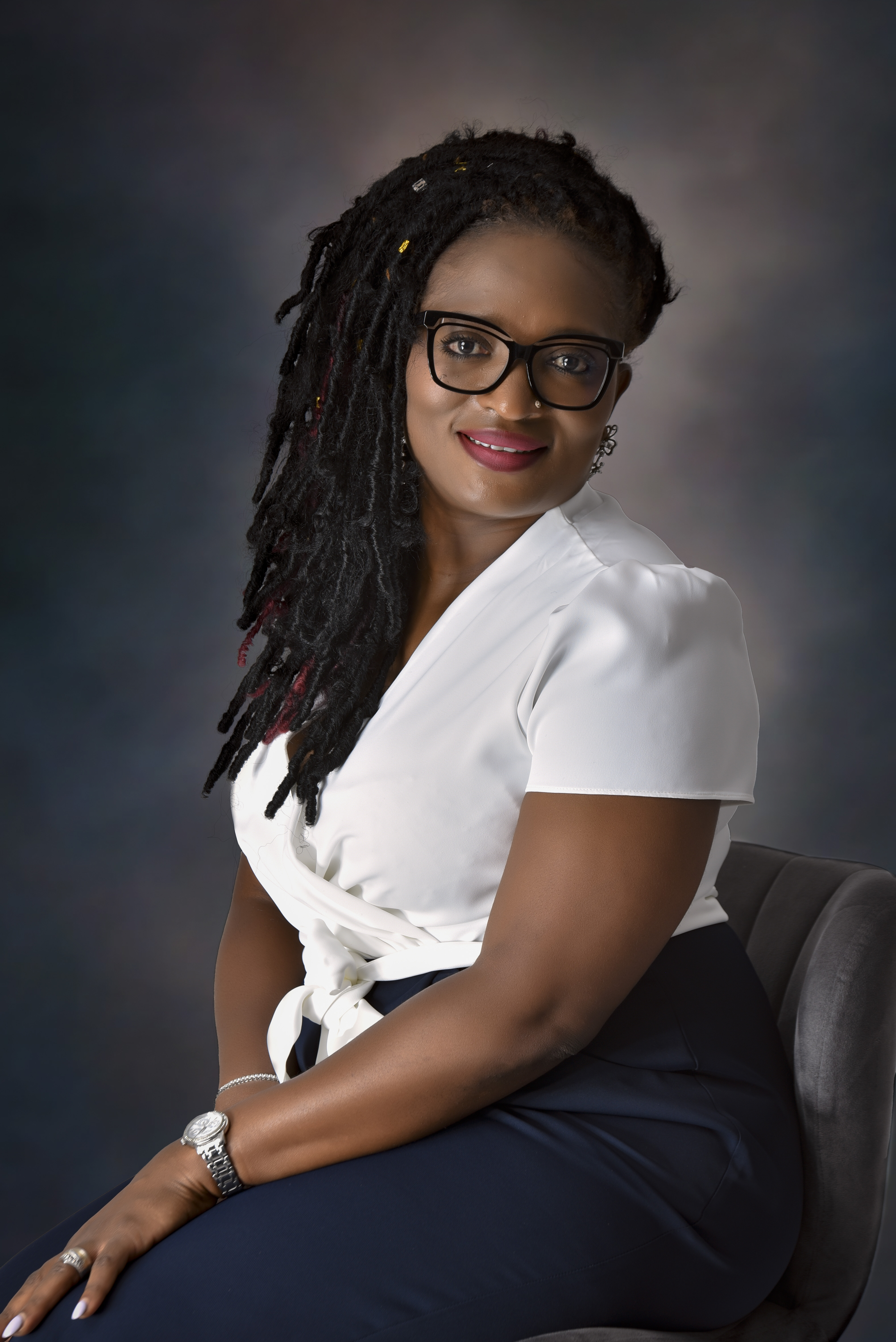 Bukola Jolugbo seated, offering one-on-one coaching